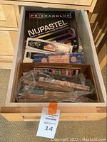 Drawer containing a box of Prismacolor NuPastel 48 soft pastel sticks, assorted pastels in plastic, and incense boxes.