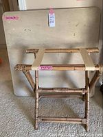 Folding table upright with bamboo luggage rack in front showing measurements.