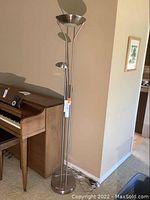 Full view of the modern standing floor lamp showing its tall structure and multiple lights.