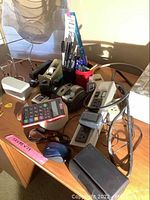Overview of the lot showing the various office supplies and power strips on a wooden desk.