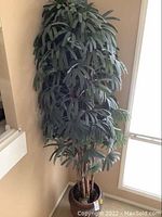 Full view of tall artificial tree with dense green foliage