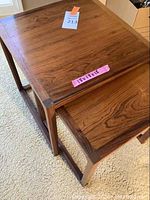 Two nested wooden tables with square tops and open rectangular legs, dimensions label visible