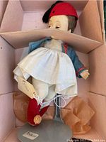 Top view of the Madame Alexander doll lying in original box, showing full outfit and box interior.