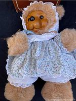 Soft plush Raikes Susie Bear in floral dress, bonnet, and lace details