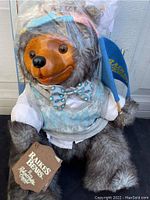 Front view of the Raikes Bear Reginald with original tag and clothing.