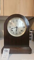 Front view of the antique Seth Thomas mantle clock showing the clock face with Arabic numerals, hands, and brass bezel.