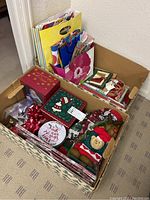 Box with Christmas gift bags, decorative gift boxes, bows, and small plush bear ornament