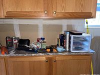 Overview of garage countertop with plastic drawers, hand tools, cookbooks, and garden supplies
