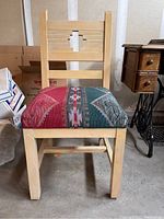 Front view of light wood chair showing Southwest patterned upholstered seat