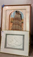 Framed Native American print featuring a figure under an archway, partly visible behind the framed sandcastle relief art, showing both pieces in one image.