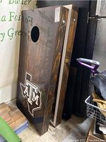 Stacked view of two Texas A&M corn hole boards showing dark stained wood surfaces with Texas A&M logos and board thickness.