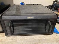 Front view of black Excalibur food dehydrator showing glass door with two black handles and Excalibur logo.