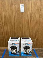 Two boxed Thermacell Patio Shield mosquito lanterns shown side by side in sealed packaging.
