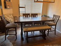 Overview of wood dining table, four chairs, and bench
