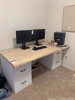 Photo of a heavy solid wood table top installed on white drawer bases, with dual computer monitors and keyboard on top.