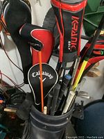 Photo of assorted golf clubs in a black blue Bang golf bag showing Krank and Callaway branded head covers and driver clubs