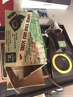 Electric putting practice ball return showing original box with vintage graphics and the device itself.