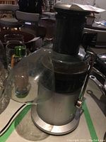 Front view of the Breville juicer showing the clear plastic chute and side locking lever.
