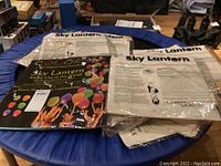 Top view of packaged sky lanterns stacked and laid out showing labeled packages with instructions and colored lantern graphics.