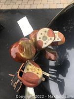 Top view of several persimmon wood golf club heads with metal plates showing wear.