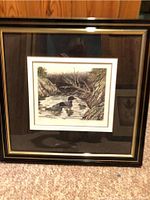 Framed loon print showing the overall artwork in the black and gold frame.