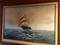Framed oil painting of a large sailing ship on the ocean showing full view with signature.