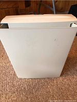 Front view of white vertical paper shredder showing plain plastic body.