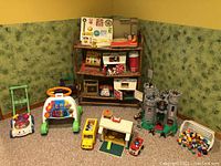 Full display of lot items including toys on shelves and floor, featuring green plastic lawnmower, activity walker, barn, castle, and basket of figurines.