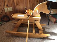 Full view of rocking horse with stick horse propped against it, showing size and details of rocking horse body and stick horse head and handle.