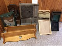 Photo showing two wooden wall shelves with heart cutouts, multiple wooden trays in natural and green paint finishes, and two rustic wooden wall hangings as background.