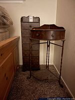 Side-by-side image of the tall cabinet with seven drawers and the corner stand with angled drawer, showing overall condition and design details.
