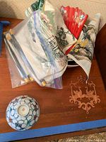 Photo showing textile wall hangings, folding fan, ceramic bowl, and wooden dragon box.