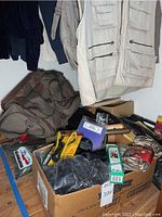 Photo of vests hanging and various bags, boxes of gear below including targets and cleaning kits.
