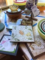 Photo showing tile and glass trivets and small amber glass bowl with wood mug rack and four purple floral Korean pottery mugs