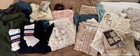 All assorted clothing items spread out showing men’s fleeces, women's sweaters, blouses, nightgowns, and socks