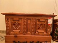 Front view showing carved floral medallion panels and braided trim