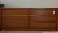 Front view of full dresser showing six drawers, wood finish and horizontal inset handles