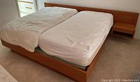 Full view of king bed frame with headboard, footboard and side floating nightstands