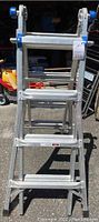 Front view of the folded aluminum ladder showing steps and folding joints with blue locking caps.