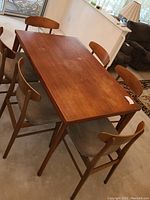 Full view of teak dining table with six chairs in original configuration