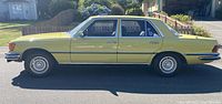 Side profile of yellow 1976 Mercedes-Benz 280 SE parked outdoors