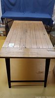 Front view of table showing plank wood top and metal leg frame