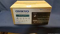 Front view of Onkyo box showing branding, Dolby Atmos logo, channel count.