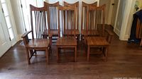 Six solid oak mission style dining chairs, including four side chairs and two armchairs, front view
