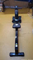 Front view of full rowing machine showing seat, rail and fan housing