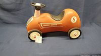 Side view of vintage metal Radio Flyer ride on toy car showing condition, color, and logo with number 8.