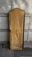 Front view of the dressing screen showing stained and torn fabric on a wooden frame with curved top