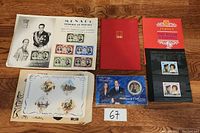 Overall assortment image showing the Monaco stamp sheet, the Jersey Royal Wedding booklet, unopened blue Royal Wedding coin set, and additional stamp sheets.