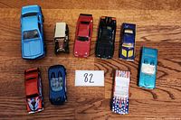Top view of all nine assorted toy cars showing different colors and styles arranged on wooden surface.