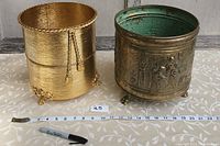 Both brass vases side by side with measuring tape and marker for size reference.